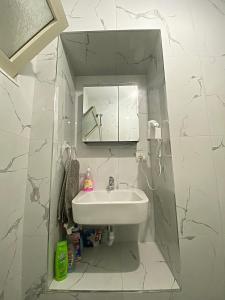 a white bathroom with a sink and a mirror at Guest House Laci in Tirana