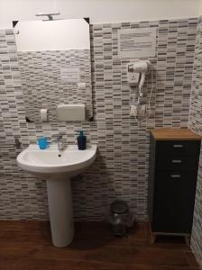 ein Badezimmer mit einem weißen Waschbecken und einem Spiegel in der Unterkunft Katane Apartment One-Room in Catania