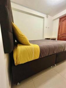 - une chambre avec un lit et une couverture jaune dans l'établissement Apartamento en Cusco, Perú., à Cusco