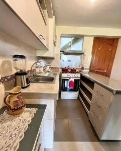 a small kitchen with a sink and a stove at Apartamento en Cusco, Perú. in Cusco