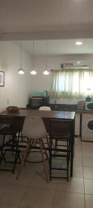 Cuesta pampa casa de campo في Toay: مطبخ مع طاولة وكراسي في غرفة