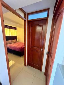 Habitación con puerta y dormitorio con cama en Apartamento en Cusco, Perú., en Cusco