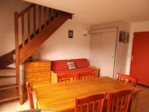 a living room with a table and a couch at Appartement charmant à La Salvetat-sur-Aout 50 m² avec jardin in La Salvetat
