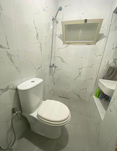 a white bathroom with a toilet and a sink at Guest House Laci in Tirana