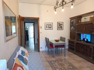 a living room with a dining room table and a television at Appartamento a 20 minuti dal Centro, Zona Residenziale Tranquilla, Free Parking, 2 Camere, 5 posti letto in Turin