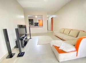 sala de estar con sofá y TV en Serene Edge, en Kampala