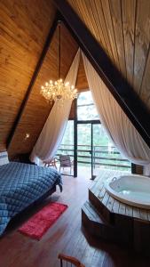 a bedroom with a bed and a chandelier at Chalé Capivari Esmeralda in Campos do Jordão