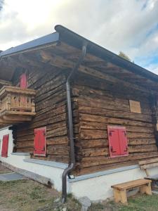 a log cabin with red doors and a balcony at Chalet Shalom in Livigno