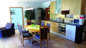 a kitchen with a wooden table and chairs and a kitchen with a table at Wellness Apartments Sophienhöhe AM TEICH in Mechernich