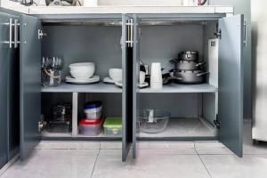 an open cabinet with dishes and utensils in it at Villas Anna Bertha in San Isidro de El General