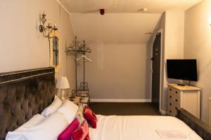 a hotel room with a bed and a television at Carlton lodge at Carlton tavern free parking in York