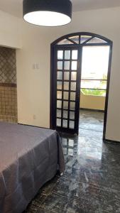 - une chambre avec un lit et une porte ouverte dans l'établissement Pousada La Bella Italia, à Aquiraz