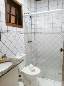 uma casa de banho com um chuveiro, um WC e um lavatório. em Pousada Le Lieu em Santo Antônio do Pinhal