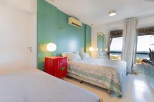 1 dormitorio con 2 camas, paredes verdes y ventana en Terraços Pirangi #17 - Conforto por Carpediem, en Parnamirim