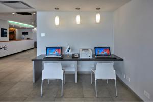 einen Schreibtisch mit zwei Laptops und zwei Stühlen in der Unterkunft City Express Junior by Marriott Puebla FINSA in Puebla