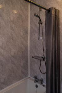 La salle de bains est pourvue d'une douche avec rideau de douche. dans l'établissement Carlton lodge at Carlton tavern free parking, à York