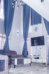 a living room with blue curtains and a couch at Captain Villa Narok in Narok