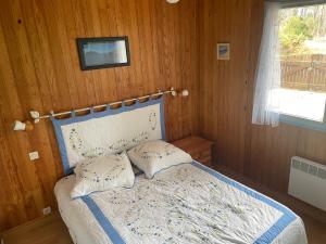 a bedroom with a bed with a tv on the wall at Maison dans une bulle de verdure in Lacanau
