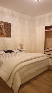 una camera bianca con un grande letto e una finestra di La Tana del Capriolo a Prati di Tivo
