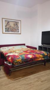 un letto con un piumone colorato in una camera di La Tana del Capriolo a Prati di Tivo
