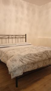 una camera da letto con un letto e un piumone bianco di La Tana del Capriolo a Prati di Tivo