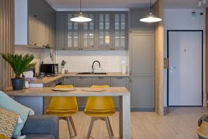 a kitchen with a table and two yellow chairs at Moon Plaza Deluxe Studios in Bucharest