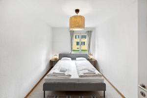 uma cama num pequeno quarto com uma janela em Cozy 2 Bedroom Apartment in Zurich em Zurique
