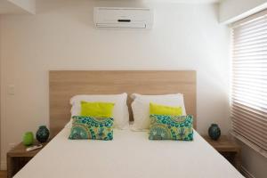 1 dormitorio con 1 cama grande con almohadas amarillas y azules en 4 Bedroom Penhouse with Pool in Leblon 012, en Río de Janeiro