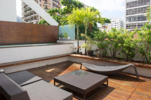 a rooftop patio with chairs and a table at 4 Bedroom Penhouse with Pool in Leblon 012 in Rio de Janeiro