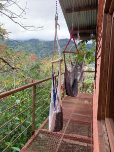 two hammocks hanging on a balcony of a house at Cabaña de montaña in Paraíso