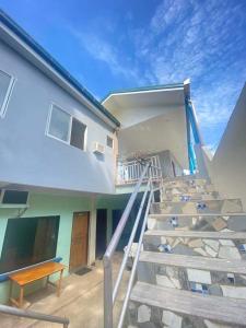 eine Treppe, die zu einem Haus mit einer Bank führt in der Unterkunft Carillo guest house in Coron