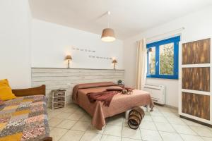 1 dormitorio con 2 camas y ventana en B&B Elianto, en Santa Maria Navarrese