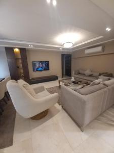 un soggiorno con 2 divani e una TV a schermo piatto di شقه مفروشه مجهزه 5***** a Il Cairo