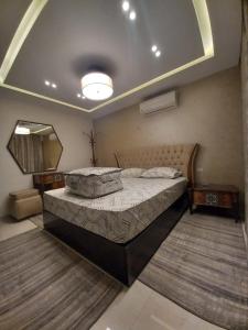 una camera con un grande letto e uno specchio di شقه مفروشه مجهزه 5***** a Il Cairo