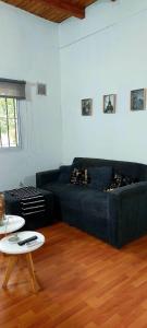 a living room with a black couch and a table at DEPARTAMENTO COMPLETO 4 Pers Mza in Las Heras