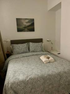 a bedroom with a large bed with a white towel on it at Rooms Cáceres in Madrid