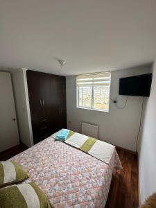 a small bedroom with a bed and a window at Apartamento punta Arenas in Punta Arenas