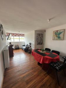 a living room with a table with a red table cloth at Apartamento punta Arenas in Punta Arenas +24 photos