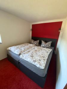 um quarto com uma cama com uma cabeceira vermelha em Ferienhaus in Schönheide im schönen Erzgebirge em Schönheide