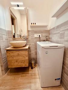 ein Badezimmer mit einem Waschbecken und einer Waschmaschine in der Unterkunft Kibilù - Via Medaglie D'Oro Centro Città con Parcheggio in Varese