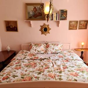 a bed with a floral comforter in a bedroom at Romantic apartment in Fjälkinge