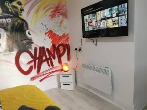 een kamer met een tv en een bed en een lamp bij Unique LFC Themed House in Liverpool