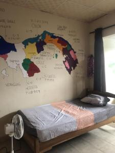 a bedroom with a map ofitzerland on the wall at The Green House in Bocas del Toro