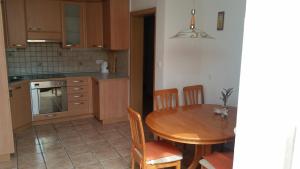 een keuken met een houten tafel en een eetkamer bij Apartment Brina in Kranjska Gora