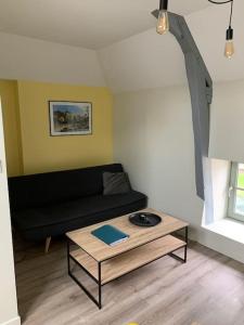 uma sala de estar com um sofá e uma mesa de centro em Appartement Ikebana - Maulévrier Cholet Puy du Fou em Maulévrier