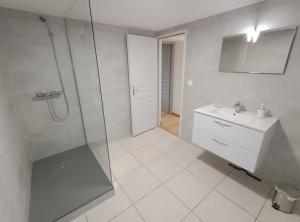 a white bathroom with a shower and a sink at La Chartreuse du Mont Outheran 