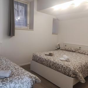 a bedroom with two beds and a window at Casa vacanza azzurra Lavarone in Lavarone