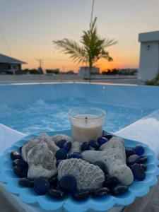 een blauwe plaat met stenen en een kaars en een drankje bij VILLA VINTAGE in Boca Chica