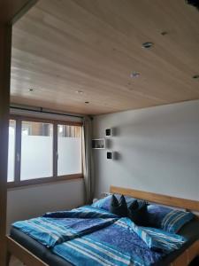 Bett in einem Zimmer mit Holzdecke in der Unterkunft Bereuter in Sibratsgfäll