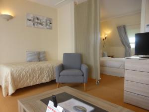 1 dormitorio con 1 cama, 1 silla y 1 mesa en Logis - Hostellerie & Restaurant Saint Louis en Bollezeele